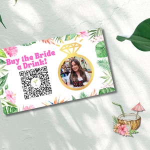 May include: A white card with a tropical floral design. The card says "Buy the Bride a Drink!" and has a QR code. A photo of a woman is in a gold circle on the card.