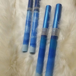 May include: Four cylindrical wands featuring a blue ombre gradient that transitions from dark navy at the top to light sky blue at the bottom. Each wand is accented with a band of silver-toned rhinestones positioned below the top section.