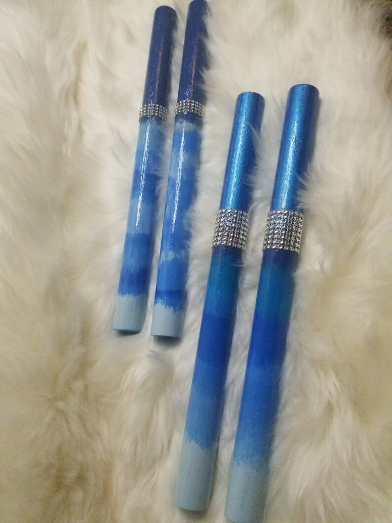 May include: Four cylindrical wands featuring a blue ombre gradient that transitions from dark navy at the top to light sky blue at the bottom. Each wand is accented with a band of silver-toned rhinestones positioned below the top section.