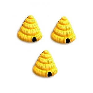 May include: Three yellow beehive shaped ornaments with black entryways.