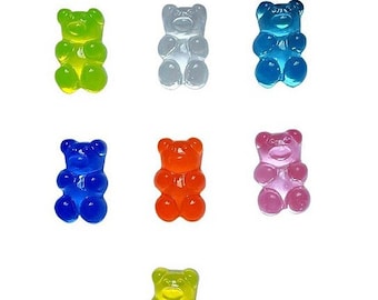 May include: A collection of colorful gummy bear candies in various colors, including green, clear, blue, orange, pink, and yellow. The gummy bears are arranged on a white background.