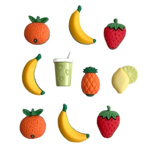May include: A set of nine colorful fruit and smoothie-themed buttons. The buttons feature a banana, orange, strawberry, pineapple, lemon, and a green smoothie in a cup. The buttons are perfect for adding a touch of fun to your crafts.