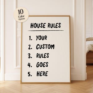 May include: A rectangular wall art print in a thin gold frame featuring the black text HOUSE RULES followed by a numbered list from 1 to 5 with the words YOUR, CUSTOM, RULES, GOES, HERE. A circular beige badge in the top left says 10 Color Options.
