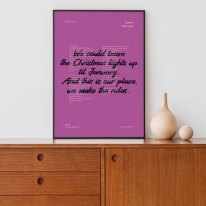 Puede incluir: Un p&oacute;ster imprimible rosa con la letra de la canci&oacute;n "Laver" de Taylor Swift. La letra est&aacute; escrita en letra cursiva negra. El p&oacute;ster est&aacute; enmarcado en un marco negro y est&aacute; colgado en una pared blanca sobre una c&oacute;moda de madera.