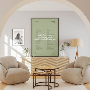 Puede incluir: Una impresi&oacute;n enmarcada de letras de canciones con un fondo verde. Las letras son para la canci&oacute;n "Good Days" de SZA. La impresi&oacute;n est&aacute; colgada en una pared en una sala de estar con dos sillones beige y una mesa de caf&eacute; de madera.