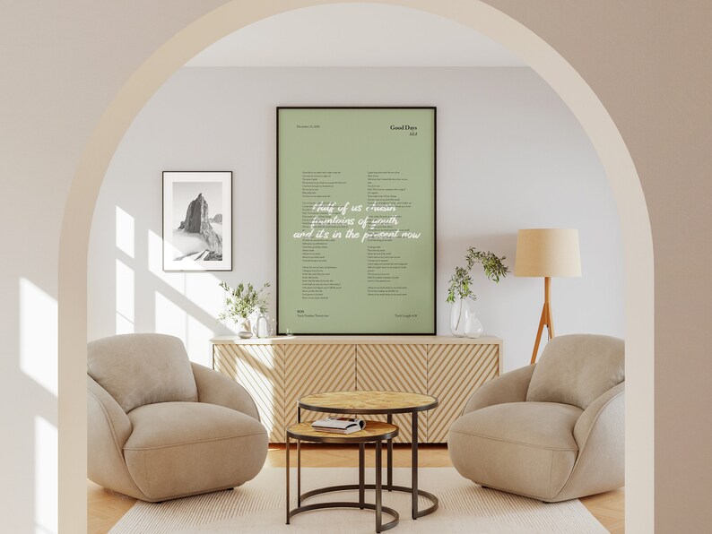 Puede incluir: Una impresi&oacute;n enmarcada de letras de canciones con un fondo verde. Las letras son para la canci&oacute;n "Good Days" de SZA. La impresi&oacute;n est&aacute; colgada en una pared en una sala de estar con dos sillones beige y una mesa de caf&eacute; de madera.