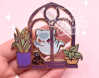 May include: A purple and gold enamel pin featuring a ghost cat in a window with plants and a crow. The ghost cat is light blue with a grumpy expression. The window frame is purple with gold accents.