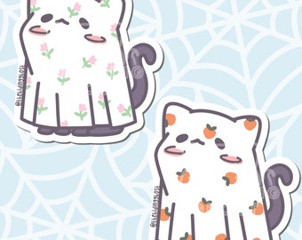 Op de afbeelding: Twee witte spook stickers met zwarte kattenstaarten. Het spook aan de linkerkant heeft een bloemenpatroon met roze bloemen. Het spook aan de rechterkant heeft een patroon van oranje perziken. Beide spoken hebben zwarte ogen en roze wangen.