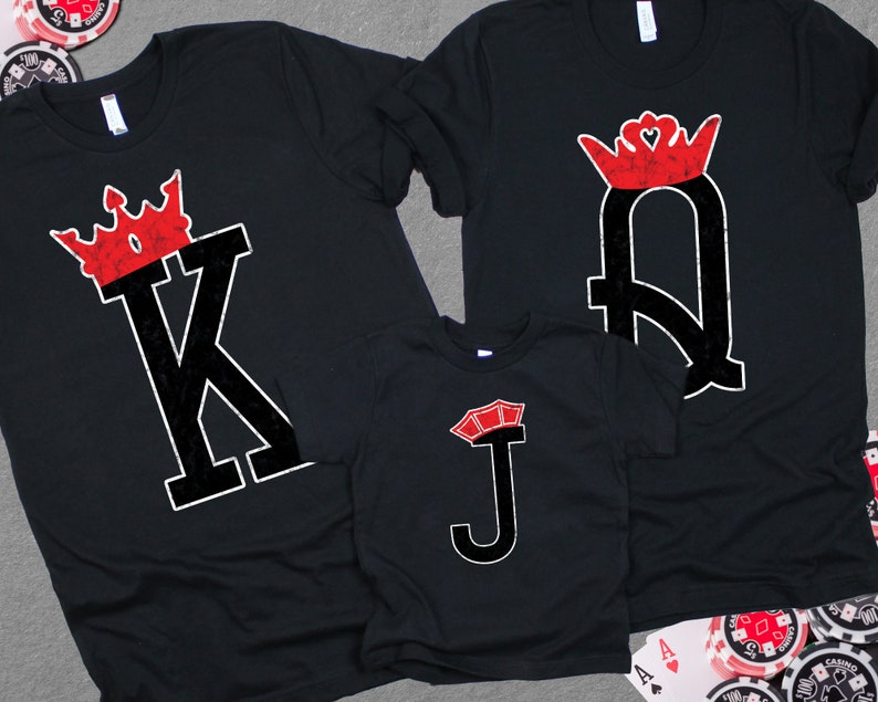 May include: Three black t-shirts with a red and white playing card design. The shirts feature a King, Queen, and Jack of Hearts.