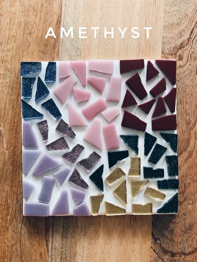 Puede incluir: Un posavasos cuadrado hecho de peque&ntilde;os trozos de vidrio en tonos de morado, rosa, burdeos, dorado y verde. El posavasos est&aacute; etiquetado con "AMETHYST" en texto blanco.
