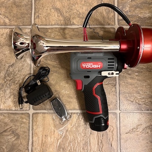 May include: A red and gray electric air horn with a chrome trumpet. The horn is plugged into a black power adapter and has a remote control. The text "HYPER TOUGH" is printed on the horn.