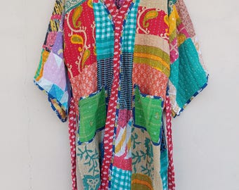 May include: A patchwork kimono robe with a V-neck and pockets. The robe features a variety of colorful fabric patches in red, green, blue, and yellow, with paisley and floral patterns. It has a red trim and a matching belt.