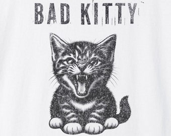 May include: White t-shirt with a black and white illustration of a kitten with the text "BAD KITTY" above it.