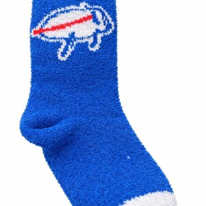 May include: A blue fluffy sock with a white cuff and toe. The sock features a white outline of a buffalo with a red stripe through it, a team logo.