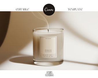 May include: A clear glass candle jar with a white label that reads "pure blend" and "French Cotton". The candle is lit and has a wisp of smoke rising from it.