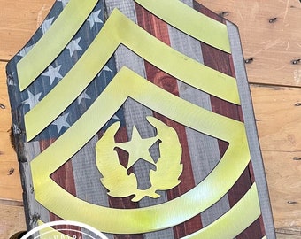 May include: A wooden sign with a US flag design and a gold metal E-5 rank insignia. The sign is decorated with a wreath and star. The sign is made by SparzandSplinterz Military Art.