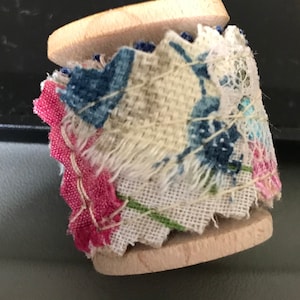 Miniature thread spool with fabric snippet roll