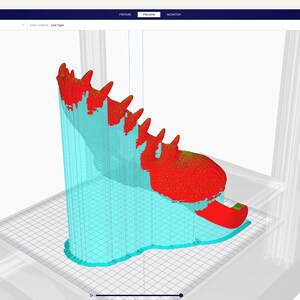 May include: A 3D model of a shoe in the process of being printed. The shoe is red and the support structure is light blue. The software interface is visible in the background.