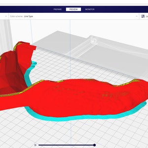 May include: A 3D model of a red object with yellow and blue lines, displayed on a computer screen. The model is being prepared for 3D printing.