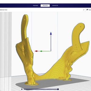 Op de afbeelding: Een 3D-model van een geel object met een complexe vorm, bekeken in een 3D-modelleringssoftware. Het model is gepositioneerd op een raster met een blauwe achtergrond. De software-interface is zichtbaar op de achtergrond.