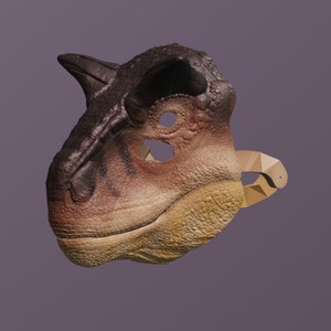 Op de afbeelding: Een dinosaurusmasker in bruin-, beige- en beigetinten, met een textuuroppervlak en een prominente hoorn. Het masker heeft ooggaten en een geometrische band. Het ontwerp lijkt op een Carnotaurus.