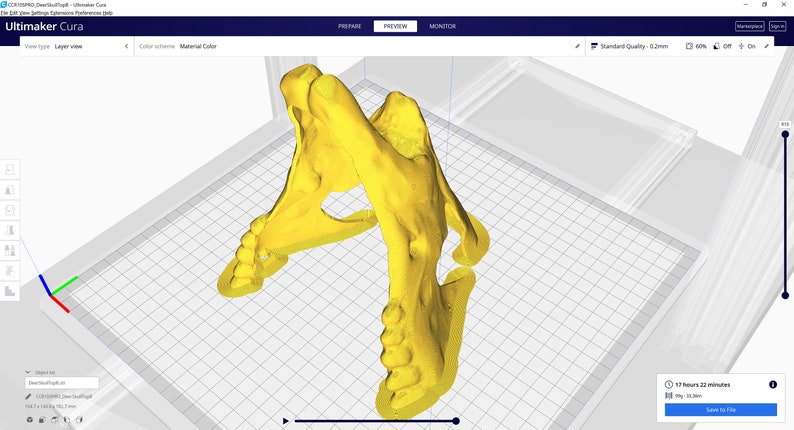 Op de afbeelding: Een 3D-model van een gele schedel, van bovenaf bekeken, wordt weergegeven op een computerscherm. Het model wordt voorbereid voor 3D-printen met behulp van de Ultimaker Cura-software. De software-interface is zichtbaar op de achtergrond.
