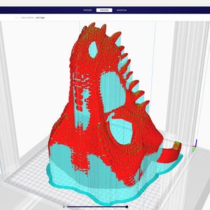 May include: A 3D model of a dinosaur skull, rendered in a 3D modeling program. The model is primarily red with turquoise and yellow accents. The image is a screenshot of the Ultimaker Cura software interface.