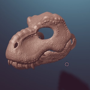 May include: A brown dinosaur head mask with a textured surface. The mask has a large eye hole and a small mouth opening.