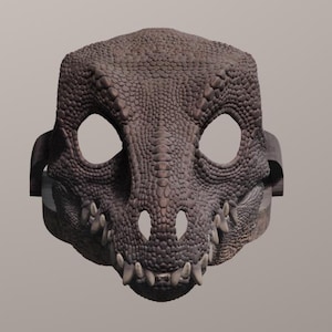 May include: A detailed, brown dragon mask with large eye openings and sharp teeth. The mask has a textured, scaly appearance and is designed to be worn. The mask is a costume accessory.