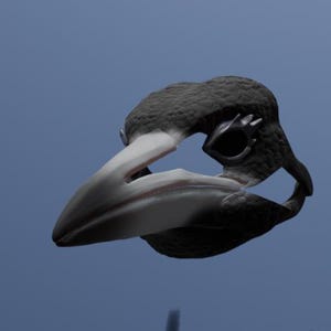 May include: A ring shaped like a bird head with a textured black surface and a smooth, light-colored beak. The eye socket is defined by a dark, hollow opening surrounded by a metallic frame, creating a detailed avian design for the finger.