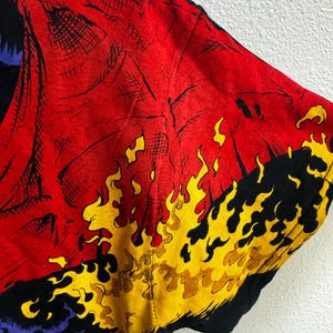 May include: Black t-shirt with a red, yellow, and blue graphic print of a skull engulfed in flames.