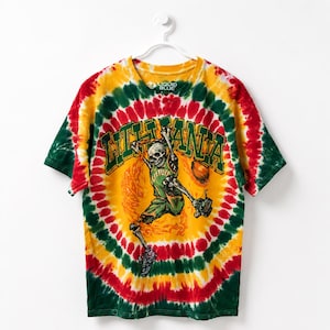 May include: Tie-dye t-shirt with a basketball-themed graphic. The shirt features a skeleton dunking a basketball, with the word "LITHUANIA" in green. The shirt has a spiral pattern in red, yellow, and green.