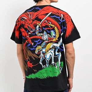 May include: Black t-shirt with a graphic print of a knight on horseback fighting a red dragon. The dragon is breathing fire and the knight is holding a sword.