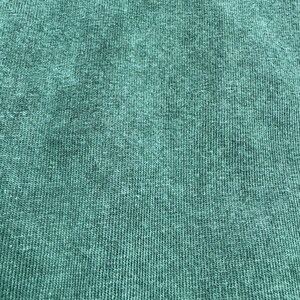 May include: Close-up of a textured, teal fabric with a subtle ribbed pattern.