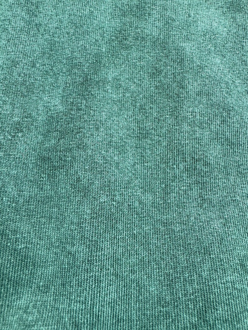 May include: Close-up of a textured, teal fabric with a subtle ribbed pattern.