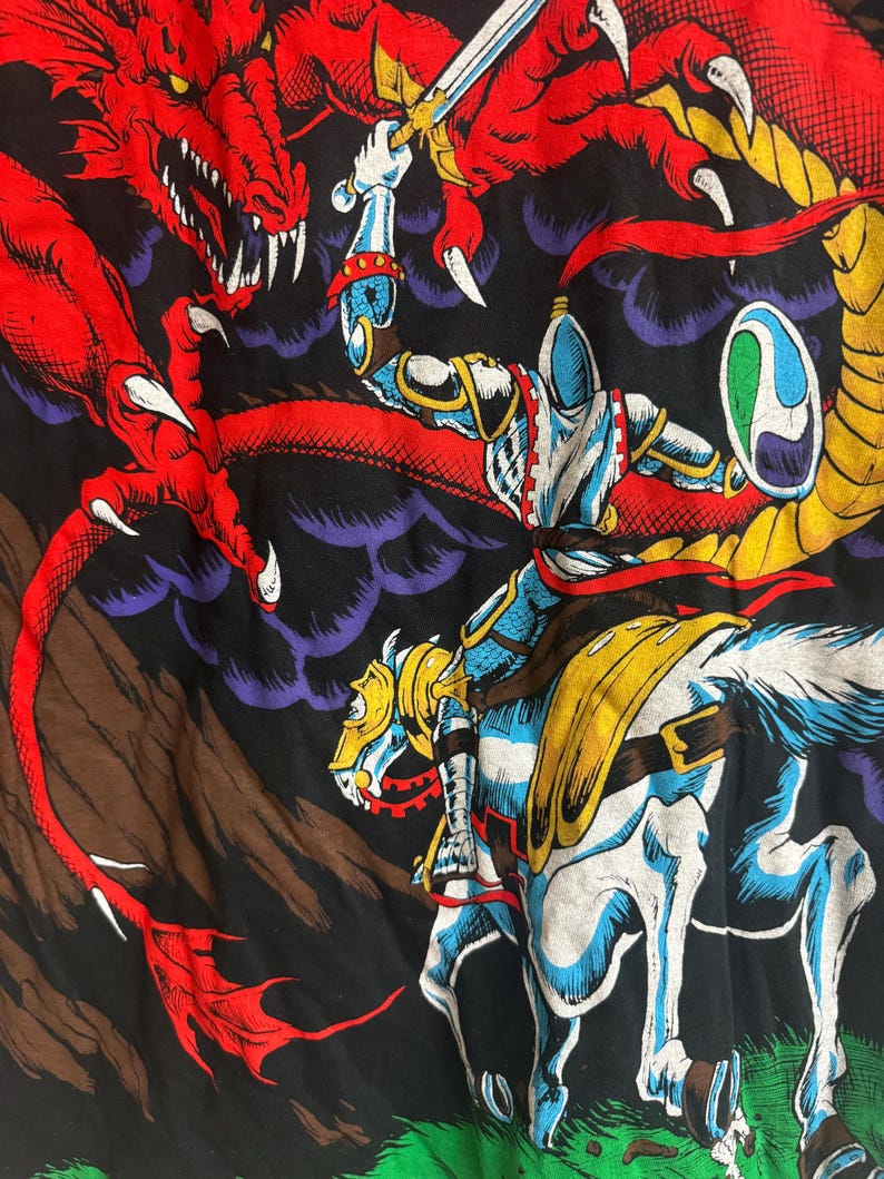 May include: A knight on horseback battles a red dragon with a sword. The knight is wearing silver armor and a blue helmet. The dragon is flying in the air with its claws outstretched. The background is a dark blue and purple sky with clouds.