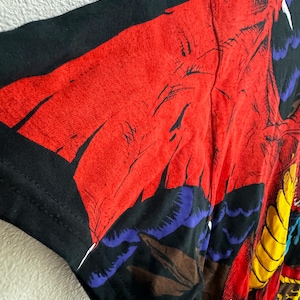 May include: Black t-shirt with a colorful graphic print of a dragon with red, yellow, blue, and brown details.