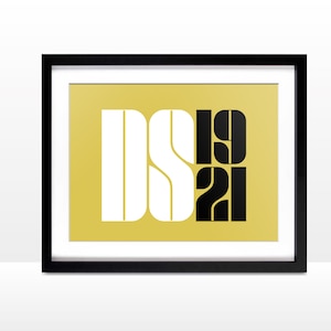 May include: A framed print with a gold background and black and white text that reads "DS1921".