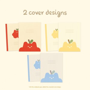 May include: Two notebook cover designs featuring a red apple, a yellow apple, and a blue apple. Each apple has a simple face and a green leaf. The text "2 cover designs" is at the top of the image. The text "with the notebook open, delete the unwanted cover design." is at the bottom of the image.