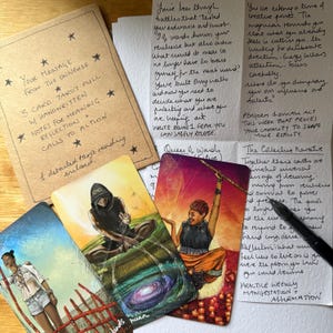 May include: A tarot card reading with three cards, handwritten notes, and a message from the universe. The cards feature colorful illustrations of figures and symbols. The reading includes calls to action and reflection.