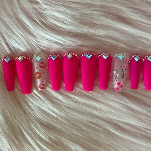 Pink matte press-on nails in long coffin style with rhinestones