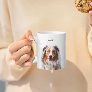 May include: White ceramic mug with a photo of a brown and white Australian Shepherd dog with the name "KODA" printed on the mug.