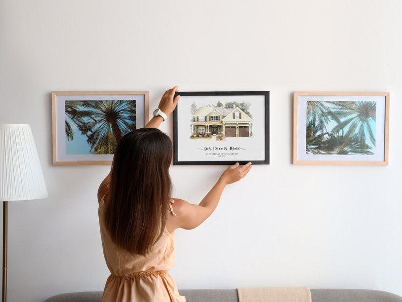 woman hanging a custom home portrait frame