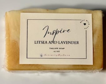 May include: A bar of yellow soap with a white label that reads "Inspire Litsea and Lavender Tallow Soap 4.5 oz Serenity By Sara" and a small heart with the words "Made with Love" in a circle.