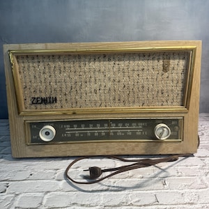 May include: A white ceramic mug with a black handle and the text "But first, coffee" in a handwritten style. The mug is on a white surface. The mug is 4 inches tall.