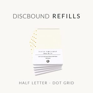 May include: A stack of white discbound refill paper with a dot grid pattern. The packaging label reads FIFTY TWO EAST, Design Plan Live, 8.5" X 5.5" Disc Bound Planner Refill Paper, 100 Sheets. The paper features gold-colored disc punch holes.