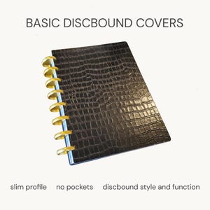 May include: A black discbound notebook cover with a textured crocodile skin pattern and gold-colored binding discs. The text BASIC DISBOUND COVERS, slim profile, no pockets, and discbound style and function are printed on the image.