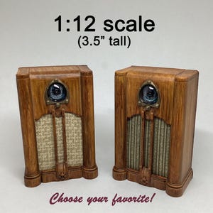 Peut inclure: Deux radios miniatures en bois, d'environ 9 cm de haut, de style vintage. Chaque radio a un cache-haut-parleur de couleur claire, un cadran circulaire et des garnitures décoratives. Le texte indique "1:12 scale" et "Choisissez votre préféré!"
