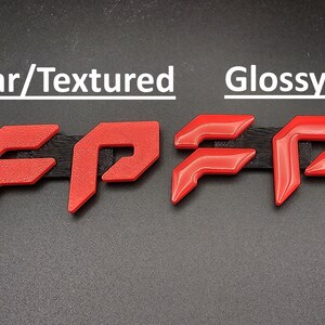 May include: Image shows two sets of red, stylized letters "FP" with different finishes. The left set has a textured appearance, while the right set is glossy. The text "Regular/Textured" and "Glossy" are above the respective sets.