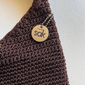 May include: A white ceramic mug with a black handle and the text "But First, Coffee" in a handwritten style. The mug is on a white surface. The mug is approximately 4 inches tall.